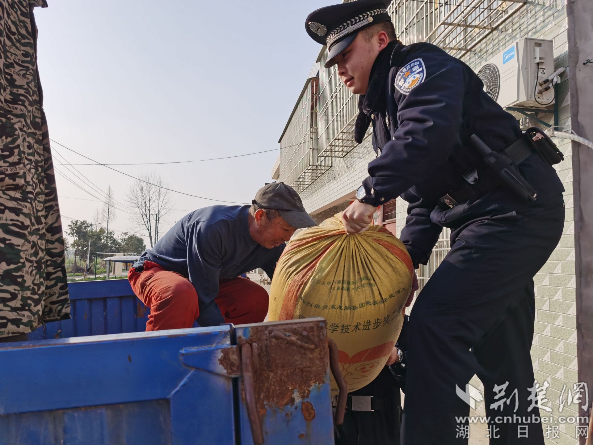 民警利用走訪間隙幫助農(nóng)民群眾干農(nóng)活.jpg.jpg