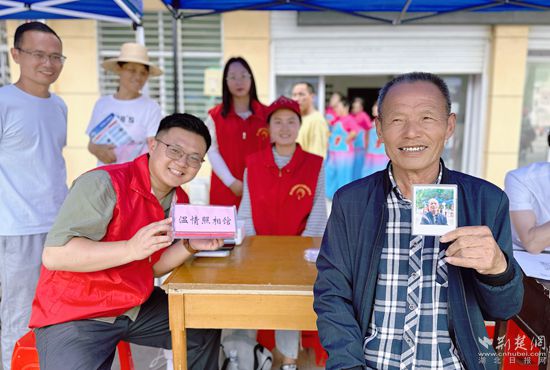 “溫情照相館”攤位上，前來(lái)照相的老人與志愿者開(kāi)心地合影留念_副本.jpg